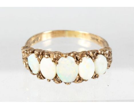 A 9CT YELLOW GOLD FIVE STONE OPAL RING.