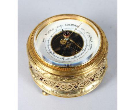 A SUPERB RUSSIAN SILVER GILT CIRCULAR TABLE BAROMETER by BOLIN, the case set with cabochon garnets and supported on bun feet.