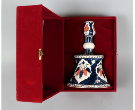 A COPY OF AN IZNIK PORCELAIN CANDLESTICK, 7.5ins high, on a velvet base.