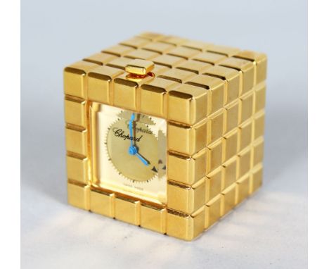 A SMALL CHOPARD GILT SQUARE TRAVELLING CLOCK. 1.25ins, in original blue box.