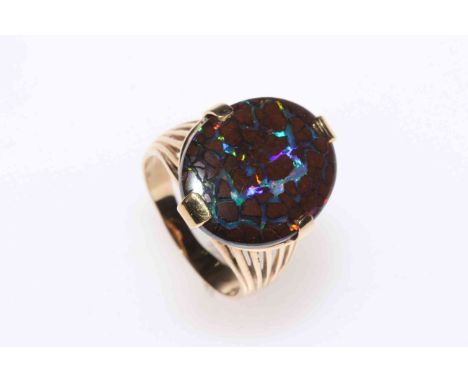 14k gold large opal ring, the oval stone set above pierced shoulders, size O.