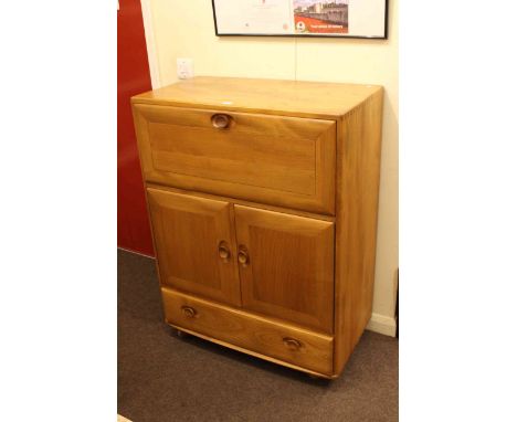 Ercol Windsor bureau, the fall front above two cupboard doors with a long drawer below, 110cm by 82cm by 43cm.