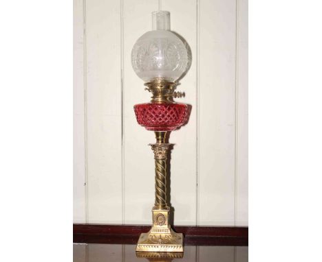 Brass corinthian column oil lamp with ruby glass reservoir and etched glass shade.