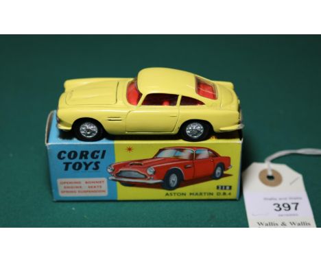 Corgi Toys Aston Martin D.B.4 (218). An example in yellow with red interior, with pronounced bonnet vent and cast spoked whee