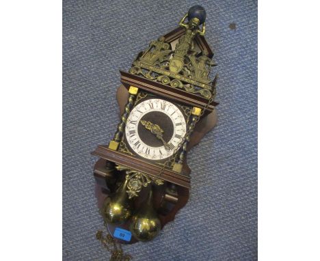A reproduction Dutch wall clock having a silvered chapter ring and finial in the form of Atlas 