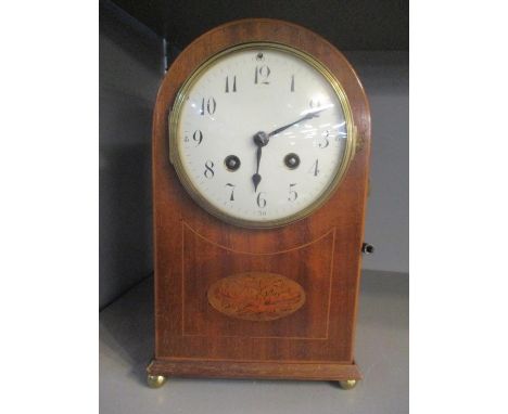 An Edwardian domed topped mantle clock having a white enamel dial and fitted with an eight day French movement 