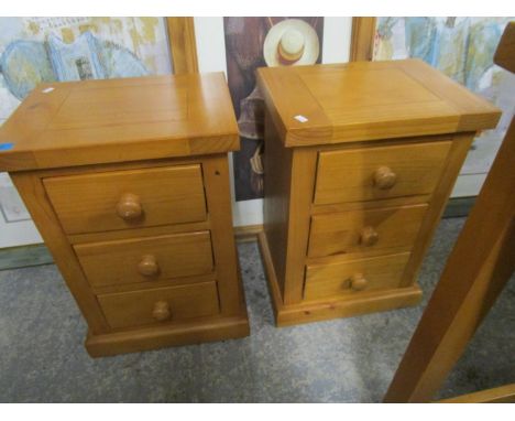 A pair of contemporary light wood bedside cabinets of three drawers on plinth bases, 22" x 15  2/8" x 11 6/8" 