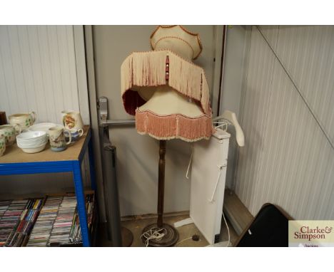 A wooden standard lamp together with two shades