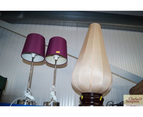 A table lamp with a silk shade together with a pair of table lamps