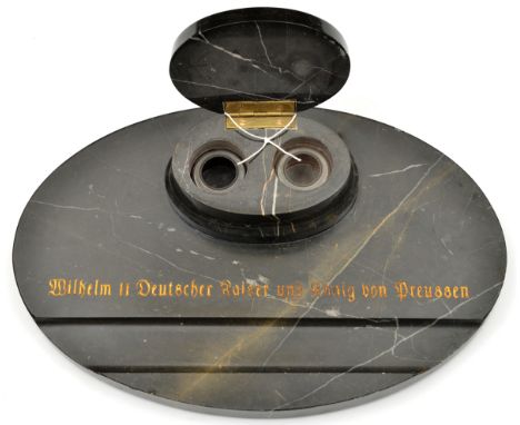 An Imperial German desk set, consisting of a pair of inkwells on an oval base, the inkwell holders and base made of polished 
