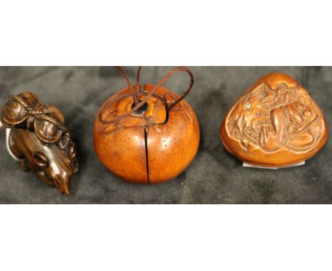 Three modern carved wood Netsuke modelled as Hotei's sack, the interior with two puppies, 4.5cm diam, a netsuke modelled as a