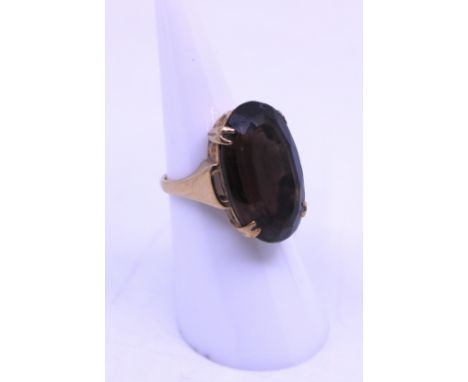 Unmarked Yellow Metal Oval Cut Brown Paste Stone Dress Ring. The Oval Cut Brown Paste Stone measures approx. 23mm in length a