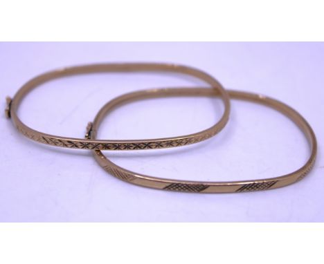 Two 9ct Yellow Gold Bangles.  Both Bangles are hallmarked "375" for 9ct Gold near the fastening.  They are both patterned on 