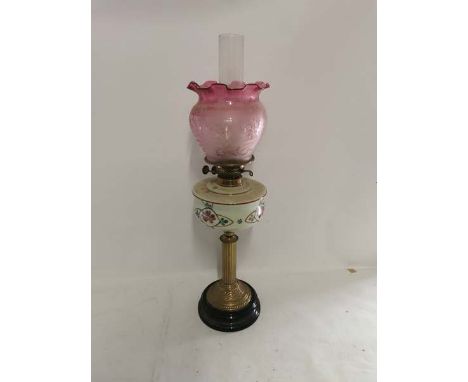 A c1900 brass columned oil lamp with painted glass well and etched cranberry glass shade. (1)&nbsp;
