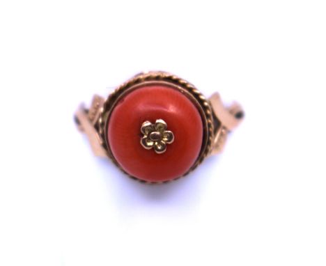 Yellow Metal Coral ring.  It has an Orange Coral Bead in the centre with Gold Flower Decoration.  Ring Size P.  Gross weight 