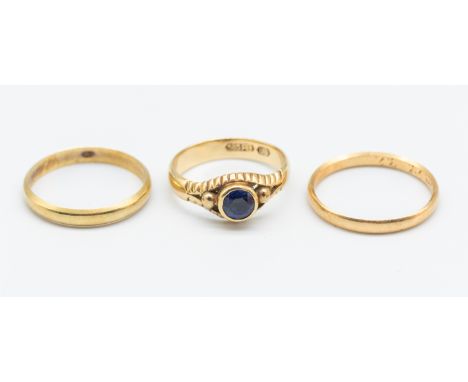 Three 14ct Gold Rings.  To include a 14ct Gold Round Brilliant Cut Sapphire Ring and two 14ct Gold Wedding Bands.  The ring a