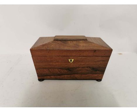 A mid 19th century Rosewood tea caddy raised on bun feet with a brass shield escutcheon. With two compartments and mixing bow