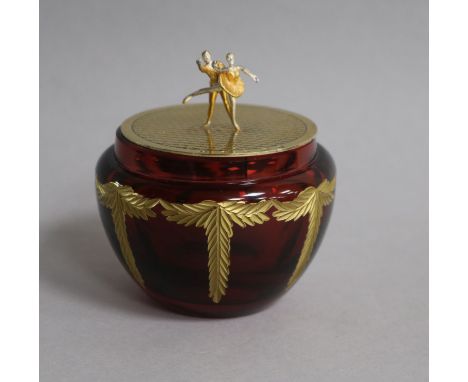 A modern Theo faberge silver gilt lidded ruby glass jar, with ballerinas finial, Birmingham, 2001, height 86mm.