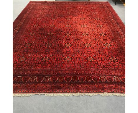 An Afghan red ground carpet 395cm x 300cm