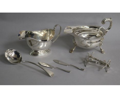 Two silver sauceboats, a pair of Victorian silver knife rests, a George III silver sauce ladle and two silver butter knives.