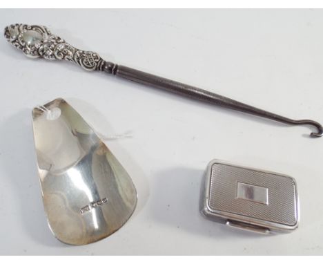 Silver topped button hook, silver shoe horn and a silver rectangular pill box with engine turned decoration