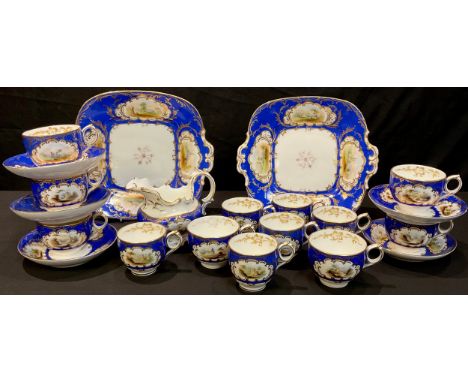 A 19th century Staffordshire part tea service, gilt edged panels painted with picturesque views on blue ground, comprising ca