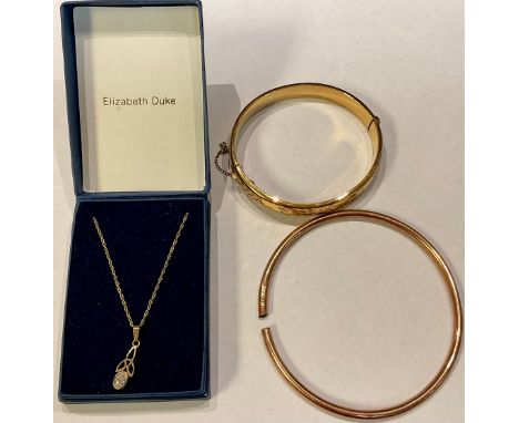 A 9ct gold necklace and pendant set with a clear glass stone, 1.4g; a 9ct rose gold bangle, marked 375, 6.3g, cut through; a 