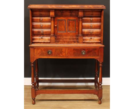 A Biedermeier flame mahogany architectural collector’s cabinet, rectangular top with convex-moulded edge above an arrangement