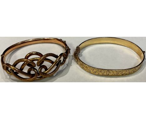 A Victorian 9ct rose gold scrolling hinged bangle, safety chain, 14g; a gold plated hinged bangle (2) 