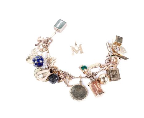 A 9ct yellow gold charm bracelet, set with charms including a globe, a cow, a Holy Bible, a football, and others, most marked