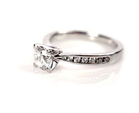 A single stone solitaire diamond ring, the brilliant-cut diamond weighing approximately 0.65carats, flanked by twelve brillia