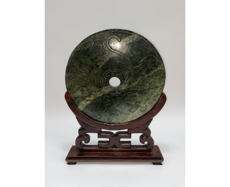 A large 19th Century Chinese jade bi-disk, decorated with tigers, on stand, diameter 36cm