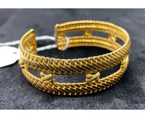 9ct Gold bangle, of curved flexible form[weight 14.6g] [size 19cm unflexed].