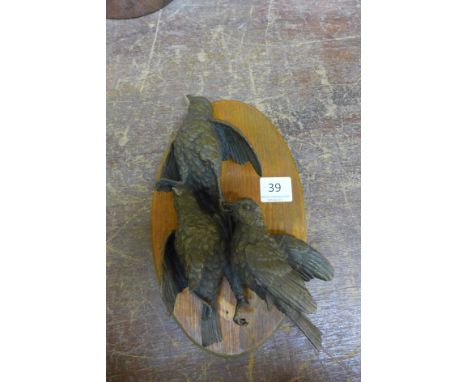 Three bronze birds, mounted on mahogany plaque
