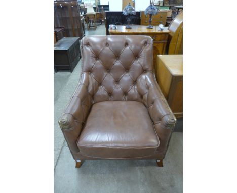 A brown leather button back armchair