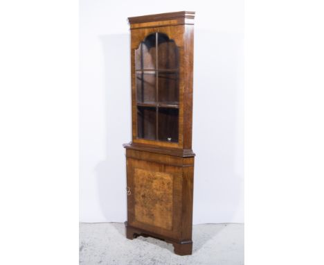 Reproduction walnut freestanding corner cupboard, glazed door to the upper section, panelled door below, bracket feet, width 