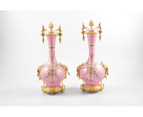 A pair of pink porcelain garniture vases, enamel bead decoration having circular gilt metal bases on four feet, lion mask and