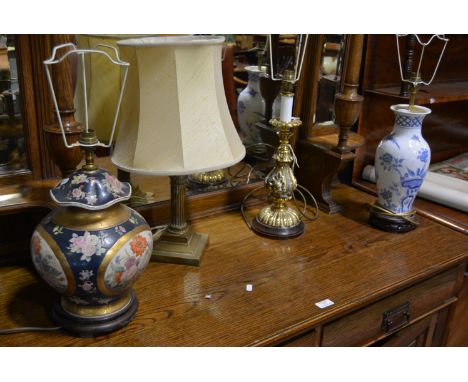Brass Corinthian column table lamp complete with shade, 53cm overall, another brass table lamp and two pottery table lamps, (