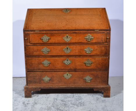 George III oak bureau, fall front writing surface enclosing an interior fitted with drawers and pigeon holes, above four long