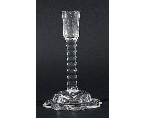 ENGLISH GLASS TAPER STICK, circa 1770, the faceted holder on a column with oval facetting, the domed foot with flowerhead sha