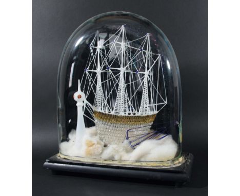 VICTORIAN GLASS FRIGGER, of a three masted sailing ship with a pilot boat and light house beside, under a glass dome with a p