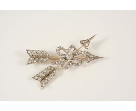 A VICTORIAN DIAMOND SET DOUBLE ARROW BROOCH formed as two crossing over arrows tied with ribbon, centred with an old brillian