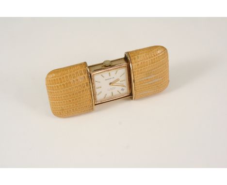 A GILT METAL TRAVELLING CLOCK BY MAPPIN the signed square-shaped dial with baton numerals and date aperture, with sliding lea