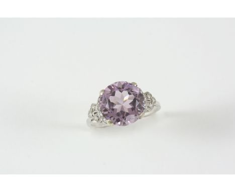 AN AMETHYST AND DIAMOND RING the circular-cut amethyst is set with single-cut diamonds to each shoulder. Size R.