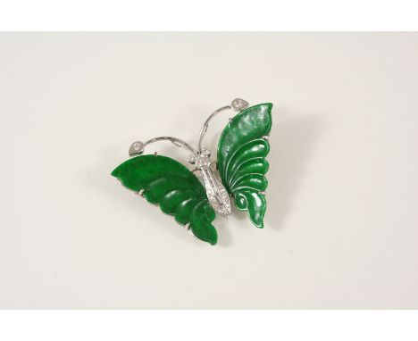 A JADE AND DIAMOND BUTTERFLY BROOCH the wings formed with sections of jade, the body set with circular-cut diamonds, 5cm. wid
