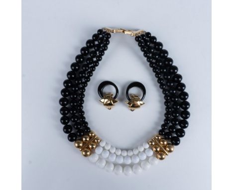 A vintage multi strand necklace with black and white beads with golden accents and a fold over clasp, and a pair of vintage b