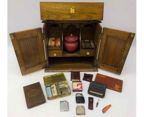 Edwardian oak Smokers cabinet with embossed copper panel doors, with some contents including Ronson & other lighters, tobacco