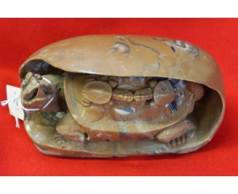 A well carved and sculptured Chinese soapstone turtle inside a rock boulder with two baby turtles on its back.