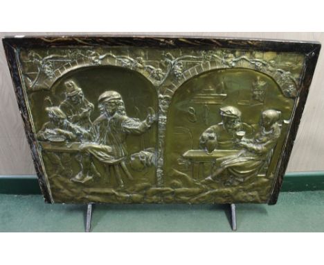 An embossed brass fire screen, decorated with a Flemish Tavern scene, 66cm x 84cm
