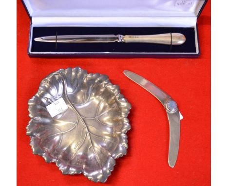 An embossed silver dish in the form of a leaf, Birmingham 1972, 74g, together with a silver handled letter opener and a white